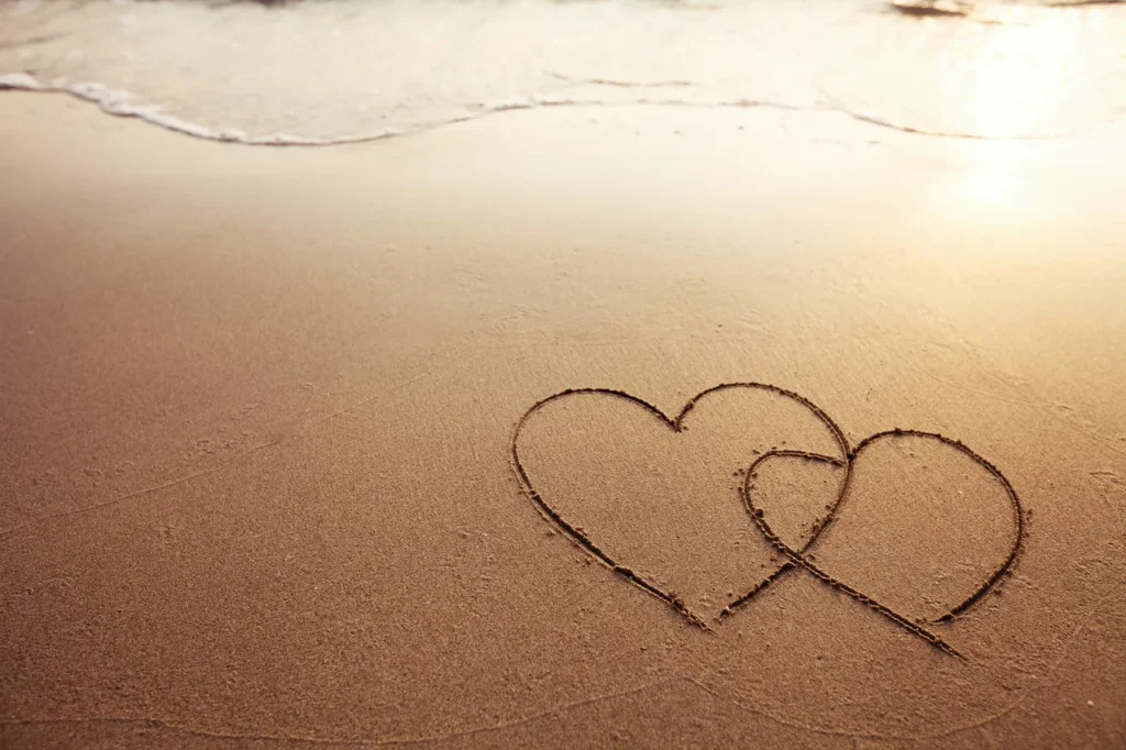 Two hearts in the sand and Love is on the beach