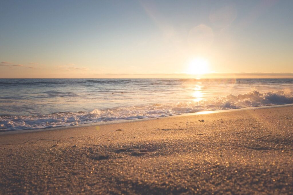 A wedding on the beach along the Northern coast with the sun setting into the ocean